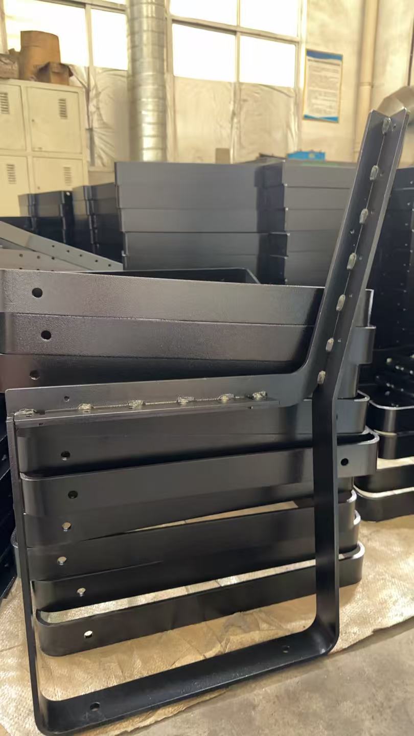 Stack of black steel bench frames in the Hannah workshop