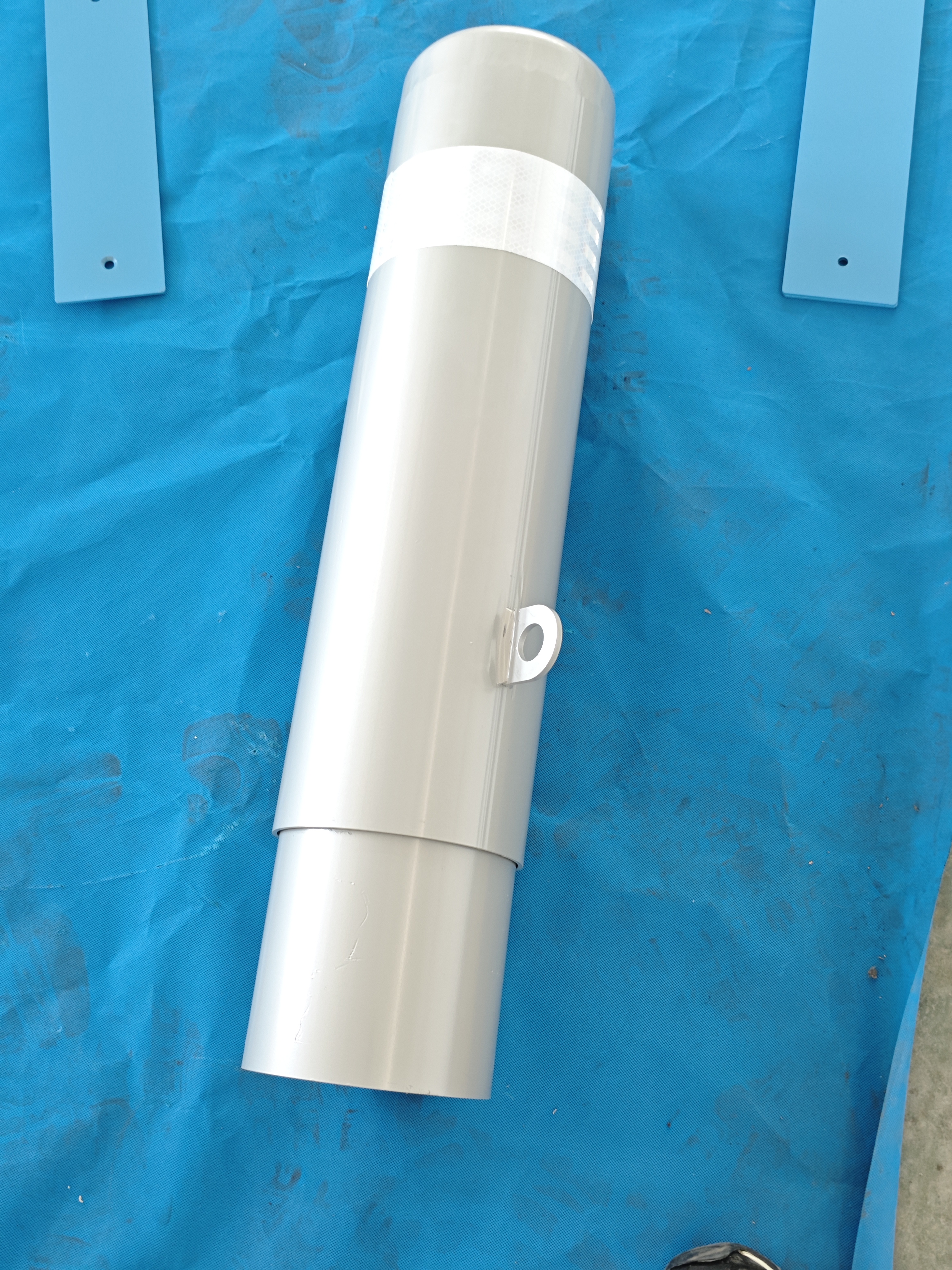 Removable steel bollard with a ring handle lying on a work mat