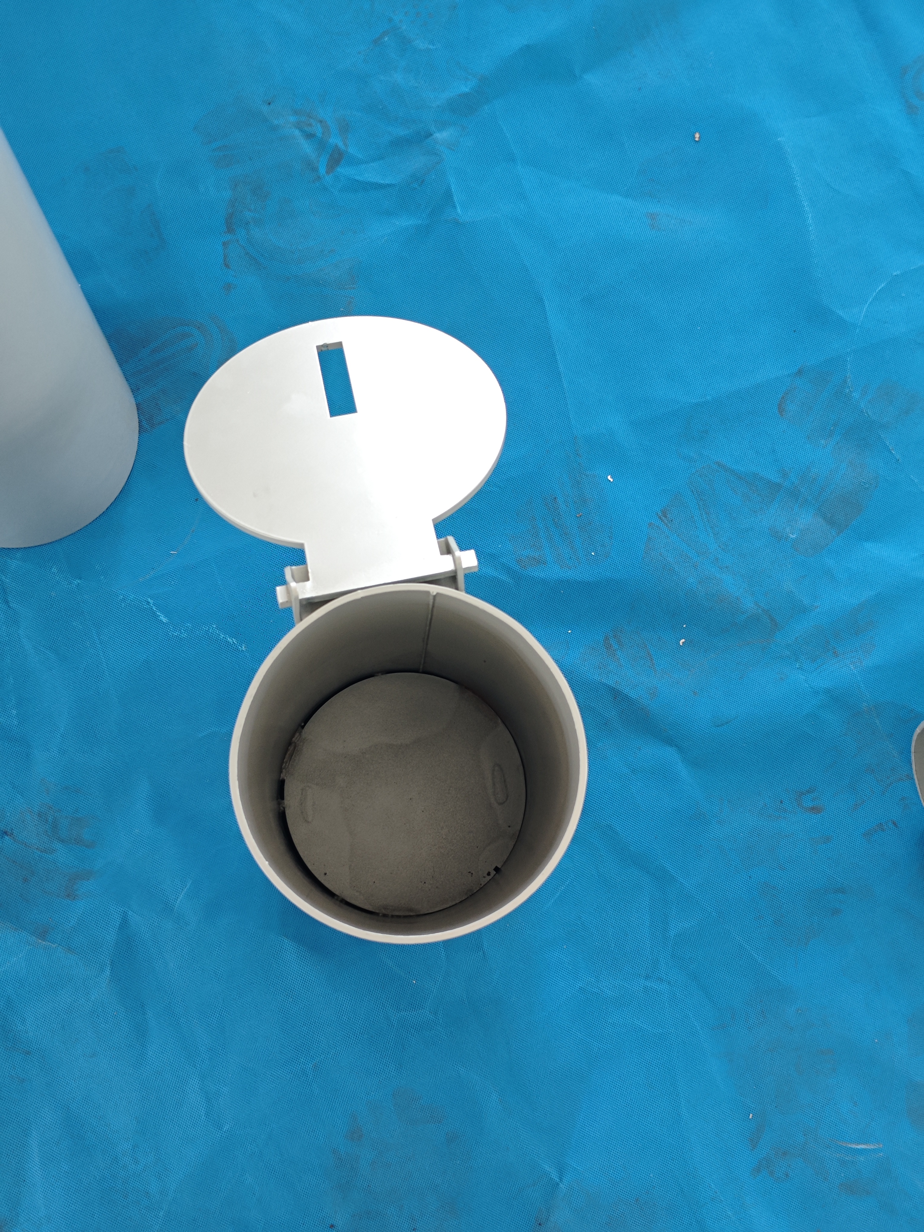 Open removable bollard cover showing the socket on the factory floor