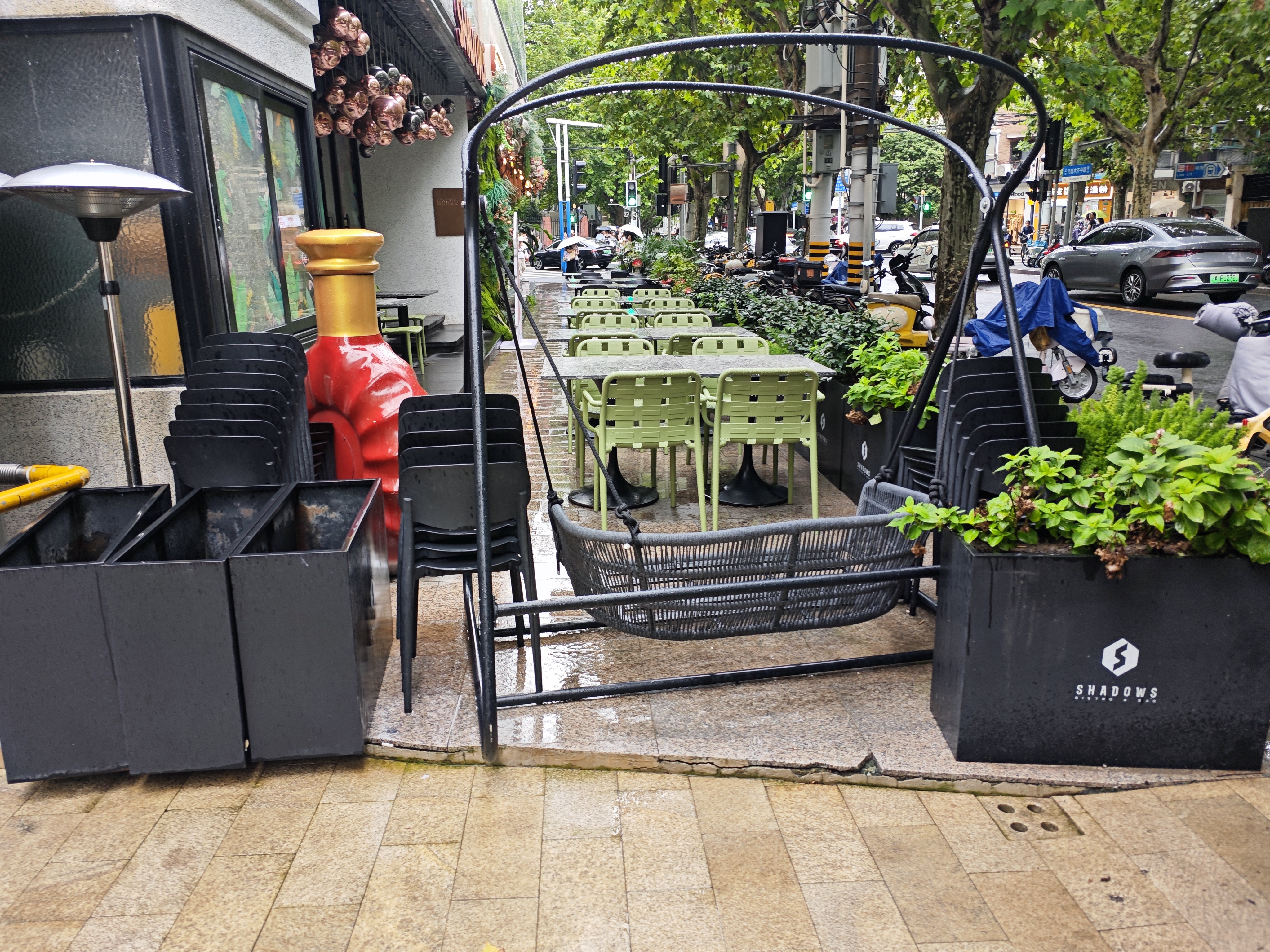 Rows of dark metal planters on a restaurant terrace